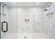Elegant shower showcasing marble herringbone tile, bronze hardware, and a seamless glass enclosure at 6335 Mount Eden Ave, Las Vegas, NV 89139