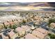 An aerial view displays the rooftops and streets of a suburban neighborhood with a mountain range in the background at 6527 Belgrave Hall Ln, Las Vegas, NV 89122