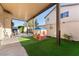 Covered back patio with artificial turf, playhouse, and seating area, perfect for outdoor enjoyment at 6527 Belgrave Hall Ln, Las Vegas, NV 89122