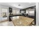 Modern kitchen with granite countertops, stainless steel appliances, and tile flooring at 6527 Belgrave Hall Ln, Las Vegas, NV 89122