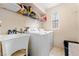 Bright laundry room featuring a utility sink, washer, dryer, storage shelf, and window at 6527 Belgrave Hall Ln, Las Vegas, NV 89122