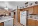 Spacious kitchen with wood cabinets, laminate floors, and a breakfast bar open to the living area at 6705 Squaw Mountain Dr # 102, Las Vegas, NV 89130