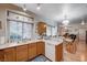 Open kitchen with wood cabinetry, neutral countertops, and a view into the dining and living areas at 6705 Squaw Mountain Dr # 102, Las Vegas, NV 89130