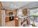 Charming kitchen featuring wood cabinets, black appliances, and a breakfast bar overlooking the outdoor patio at 6705 Squaw Mountain Dr # 102, Las Vegas, NV 89130
