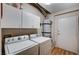 Functional laundry room with washer, dryer, storage cabinets, and access to an exterior door at 6705 Squaw Mountain Dr # 102, Las Vegas, NV 89130