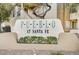 The Pueblo at Santa Fe signage is nestled amongst trees and shrubbery, adding a natural touch to the neighborhood entrance at 6705 Squaw Mountain Dr # 102, Las Vegas, NV 89130