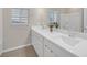 Bright bathroom features dual sinks, white cabinets, and a large mirror at 7177 W Camero Ave, Las Vegas, NV 89113