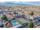 Aerial view of community with pool, tennis courts, and surrounding city and mountain views at 7300 Pirates Cove Rd # 2093, Las Vegas, NV 89145