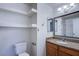 Bathroom featuring single vanity, framed mirror, tiled countertops, shelving, toilet, and towel hooks at 7300 Pirates Cove Rd # 2093, Las Vegas, NV 89145
