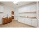 Well-lit laundry room features custom cabinetry, a sink, tile floor, and ample counter space at 7466 Matilda St, Las Vegas, NV 89113