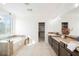 Bright main bathroom featuring double sinks, a soaking tub, and a walk-in closet at 7466 Matilda St, Las Vegas, NV 89113