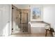 Bright main bathroom with a glass shower, a soaking tub, and tile surround at 7466 Matilda St, Las Vegas, NV 89113