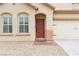 Close-up of a home's inviting entrance, featuring a red door and desert landscaping at 7652 Borealis St, Las Vegas, NV 89123