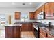 Charming kitchen with stainless steel appliances, wooden cabinets, and tile flooring at 7652 Borealis St, Las Vegas, NV 89123