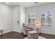 Bright living room featuring hardwood floors, chair with ottoman, and natural light from shuttered windows at 7652 Borealis St, Las Vegas, NV 89123