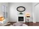 Bright living room featuring hardwood floors, a fireplace, an oval mirror, and natural light at 7652 Borealis St, Las Vegas, NV 89123