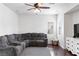 Cozy living room featuring a large sectional sofa, hardwood floors, and a ceiling fan at 7652 Borealis St, Las Vegas, NV 89123