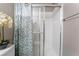Bathroom with a glass door shower featuring white tiles and stylish shower curtain at 7950 W Flamingo Rd # 1037, Las Vegas, NV 89147