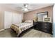 Bedroom featuring a ceiling fan, dresser with mirror, and a queen bed with patterned bedding at 7950 W Flamingo Rd # 1037, Las Vegas, NV 89147