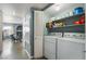 Well-organized laundry room with washer, dryer, storage shelves, and an adjacent sitting room at 7950 W Flamingo Rd # 1037, Las Vegas, NV 89147