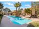 A refreshing community swimming pool surrounded by seating, lush landscaping, and palm trees at 7950 W Flamingo Rd # 1037, Las Vegas, NV 89147