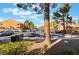 Apartment complex street view, showing parking, building exterior, and mature trees under a bright blue sky at 7950 W Flamingo Rd # 1037, Las Vegas, NV 89147
