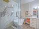 A luxurious bathroom featuring a glass shower, soaking tub and modern fixtures with light wood shelving at 817 Peachy Canyon Cir # 204, Las Vegas, NV 89144