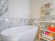 Close up on a soaking tub next to shelves with colorful toys and decor against the marble wall at 817 Peachy Canyon Cir # 204, Las Vegas, NV 89144