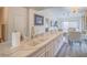Modern kitchen features a marble countertop island, white cabinets, and gold hardware at 817 Peachy Canyon Cir # 204, Las Vegas, NV 89144