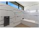 Bright bathroom features marble walls, a modern tub, and a rainfall shower system at 9 Boulderback Dr, Henderson, NV 89012