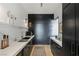 A modern butler's pantry with sleek black cabinets, marble countertops, and contemporary fixtures and decor at 9 Boulderback Dr, Henderson, NV 89012