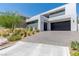 Stunning modern home featuring a clean white exterior, black trim, two-car garage, and landscaped front yard at 9 Boulderback Dr, Henderson, NV 89012