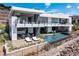 Two-story modern home with a backyard pool, outdoor kitchen, lounge chairs, and desert landscaping at 9 Boulderback Dr, Henderson, NV 89012