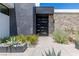 Contemporary front entrance with sleek black door, stone and tile accents, and minimalist landscaping at 9 Boulderback Dr, Henderson, NV 89012