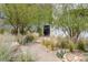 Landscaped front yard featuring native plants, trees, and a modern walkway at 9 Boulderback Dr, Henderson, NV 89012