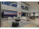 Open-concept living space with high ceilings, modern lighting, and city views through sliding glass doors at 9 Boulderback Dr, Henderson, NV 89012