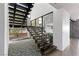 Modern staircase with a black metal railing and open risers leading to a downstairs living area at 9 Boulderback Dr, Henderson, NV 89012
