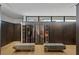 Spacious walk-in closet featuring custom wood cabinets, mirrored doors, and light oak wood floors at 9 Boulderback Dr, Henderson, NV 89012