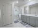 Well-lit bathroom features double sinks, gray cabinets, and a glass-enclosed shower at 10279 Fragrant Apple Ct, Las Vegas, NV 89141
