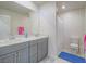 Well-lit bathroom featuring a double vanity, mirrors, and a shower with modern fixtures at 10279 Fragrant Apple Ct, Las Vegas, NV 89141