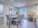 Cozy dining area with modern chairs and a stylish table, bathed in natural light from sliding glass doors at 10279 Fragrant Apple Ct, Las Vegas, NV 89141