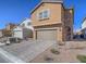 Two-story home featuring a brown stucco exterior, a two-car garage, and desert landscaping at 10279 Fragrant Apple Ct, Las Vegas, NV 89141