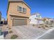 Two-story home featuring a brown stucco exterior, a two-car garage, and desert landscaping at 10279 Fragrant Apple Ct, Las Vegas, NV 89141