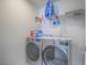 Efficient laundry room featuring a modern washer and dryer with storage shelving at 10279 Fragrant Apple Ct, Las Vegas, NV 89141