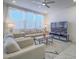 Bright living room with modern decor, large windows, plush seating, and sleek entertainment center at 10279 Fragrant Apple Ct, Las Vegas, NV 89141