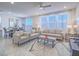 Bright living room with large windows, neutral-toned sofas, ceiling fan, and tile flooring throughout at 10279 Fragrant Apple Ct, Las Vegas, NV 89141