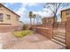 Backyard featuring brick pavers, green grass, a retaining wall and community fencing at 1152 Gecko Rd, Henderson, NV 89002