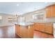 Bright kitchen with tile floor, kitchen island, and natural wood cabinets offers a warm and inviting space at 1152 Gecko Rd, Henderson, NV 89002