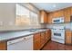 Well-lit kitchen featuring white appliances, neutral countertops, and warm wood cabinetry at 1152 Gecko Rd, Henderson, NV 89002