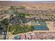 Gorgeous aerial view of a community featuring a golf course, putting green, tennis courts, and desert landscape at 1407 Wheelwright Ct, Mesquite, NV 89034